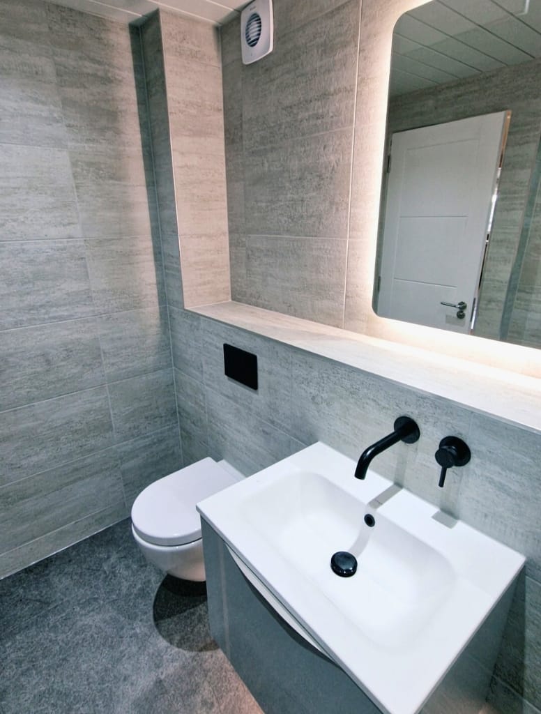 Bathroom with grey vanity and black wall mounted tap in Jordanhill